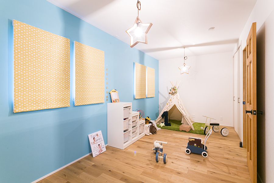 テーマカラーであるブルーの壁紙と可愛い星型照明がある子供部屋。
