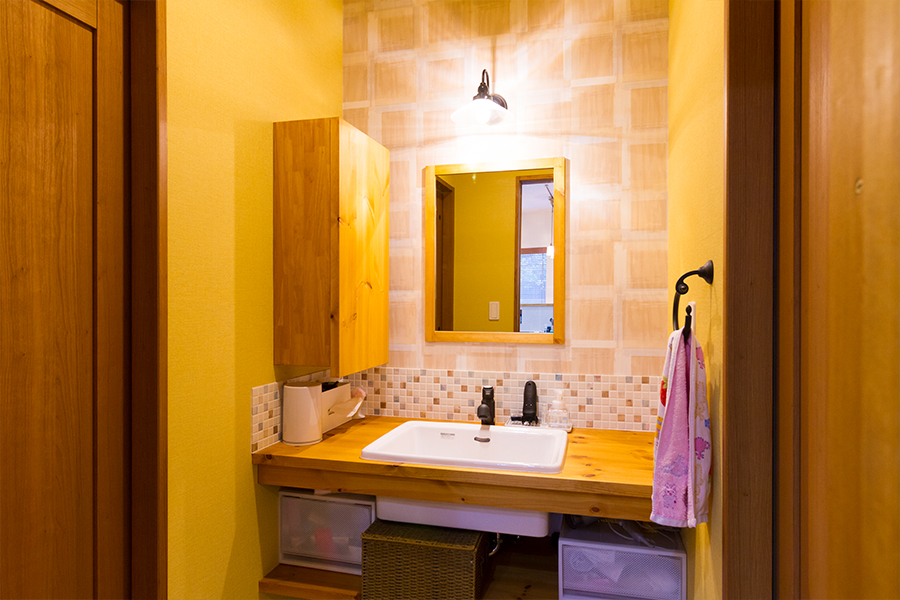 洗面室は、暖かみのある色で明るい空間に