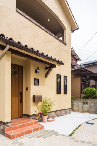 外壁は黄色い塗り壁で仕上げスッキリ三角屋根のお家です